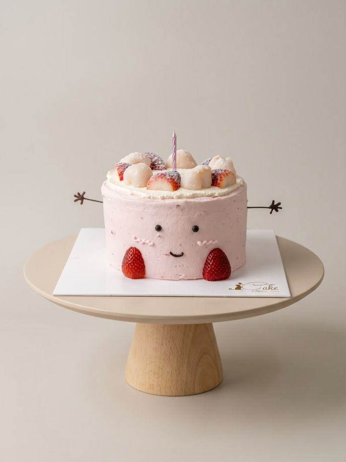 Pink strawberry Jellycat-inspired chiffon cake with a smiling face, chocolate arms and strawberry feet by iCake Melbourne